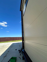 Общий вид здания с козырьком и водосточной системой