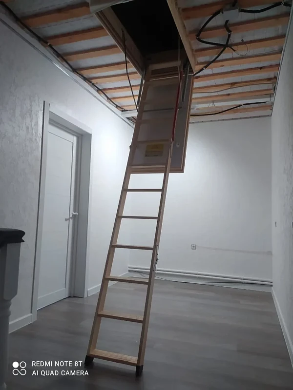 Установленная чердачная лестница с деревянными ступенями и люком