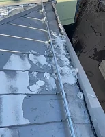 Край фальцевой кровли со снегозадержателями и снегом