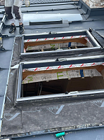 Монтажник устанавливает рамы мансардных окон на крыше