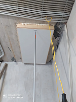 Закрытый люк чердачной лестницы с белой крышкой и стержнем для открывания