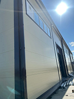 Стена здания с водосточной трубой и материалами