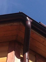Водосточная система Металл Профиль, угловой элемент на деревянном доме