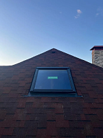 Мансардное окно на кровле из гибкой черепицы, крупный план