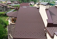 Крупный план кровли из гибкой черепицы с водосточной системой