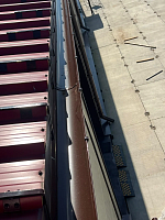 Коричневый водосточный желоб на краю кровли