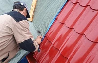 Монтажник крепит металлочерепицу Металл Профиль Ламонтерра