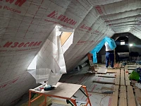 Монтаж пароизоляции в мансарде, мастер за работой