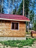 Деревянный дом с бордовой крышей и системой водоотведения