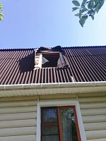 Открытое мансардное окно на металлической кровле