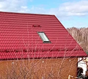 Мансардное окно в металлочерепице на крыше кирпичного дома