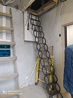 Установленная чердачная лестница ножничного типа в интерьере