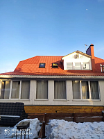 Загородный дом с мансардными окнами и слуховым окном зимой