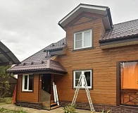 Фасад дома с кровлей Grand Line Classic PurPro Matt RAL8017 и мансардными окнами