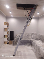 Алюминиевая чердачная лестница Oman Alu Profi Lite в разложенном виде в комнате