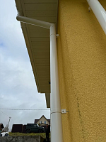 Белая водосточная труба Döcke Premium ПВХ с кронштейном на стене