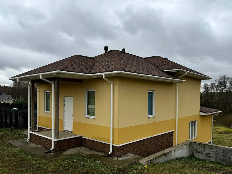 Общий вид дома с белым водостоком Döcke Premium ПВХ, несколько водосточных труб