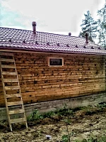 Коттедж с бордовой кровлей, снегозадержателями и лестницей